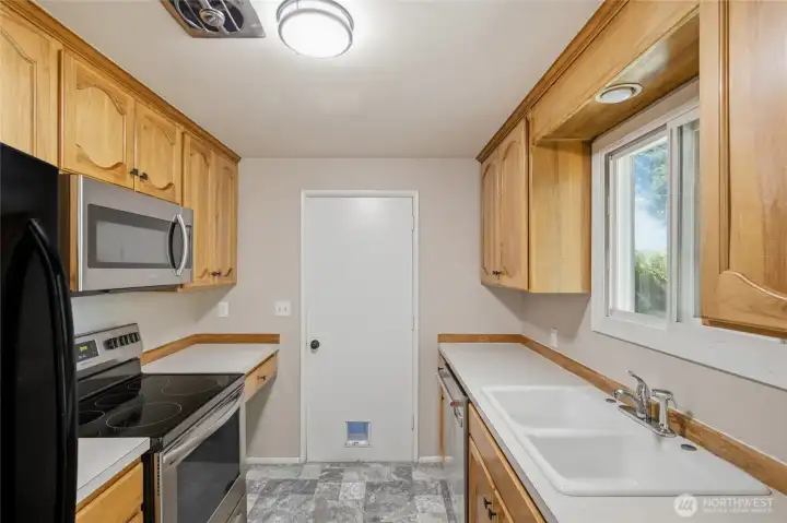 Well-appointed galley kitchen with custom hickory cabinets, stainless steel appliances, abundant storage, and durable countertops. A practical layout designed to maximize efficiency and keep everything within easy reach.