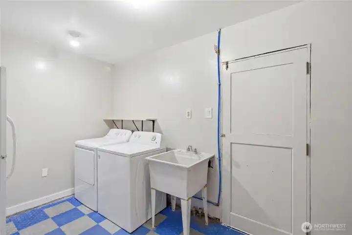 Spacious laundry room with utility sink, washer and dryer, and room for additional storage. Designed for everyday convenience and household functionality.
