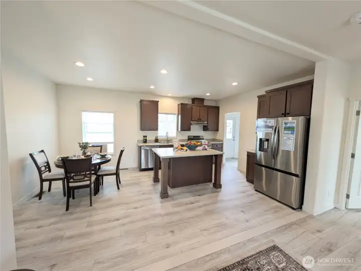 Model Home: Kitchen w/island & dining area, utility room in background.