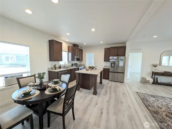 Model Home: Looking from the dining area through the kitchen to the utility room behind & the family room to the right.