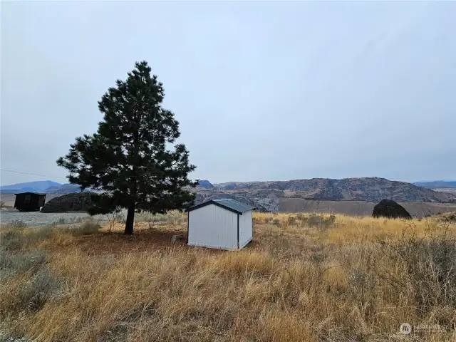 Level building site option with storage shed.