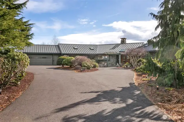 Large asphalt circular driveway with extra parking.