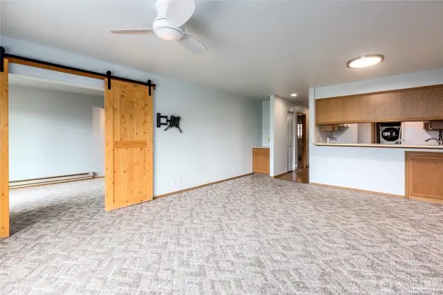 Living/dining room looking towards primary bedroom with barn doors.