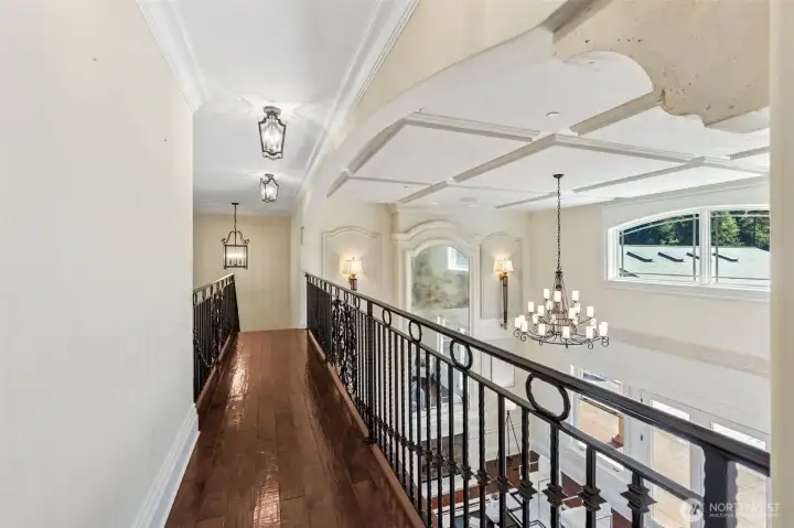 This beautiful wrought iron railing overlooks the living room below. You can see the intricately detailed ceiling up close. At the other end of the hall is the 2nd laundry room.