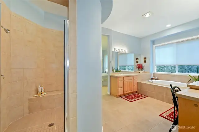 Large step in shower with a bench.