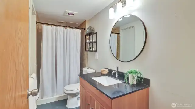 This refreshed bathroom offers a modern vanity, contemporary finishes, and a tiled walk-in shower.
