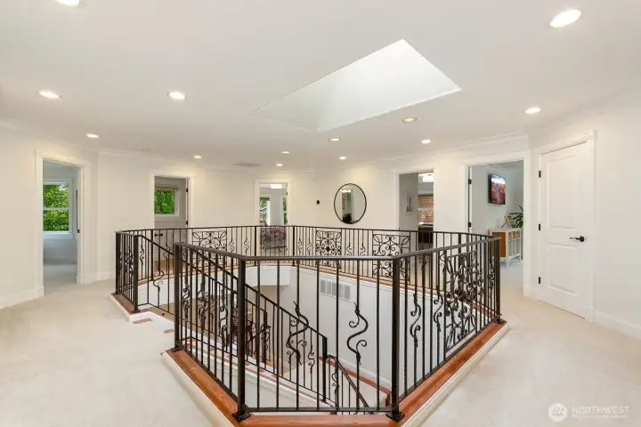 Upon exiting the primary suite, you'll enter the circular hallway with sightlines to the other three bedrooms, bonus room, to bathrooms, and laundry. Such a unique layout that brings in so much light.