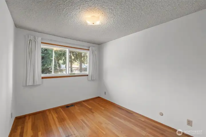 Main floor bedroom with original wood flooring
