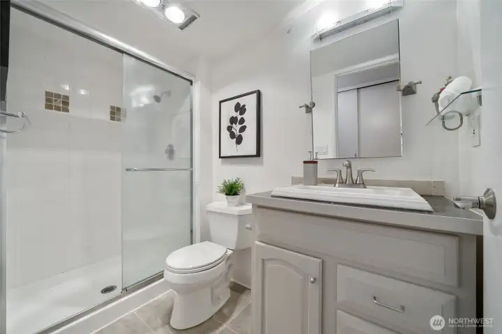 Step into the primary bathroom with stylish designer tile adorning the shower for a luxurious feel.