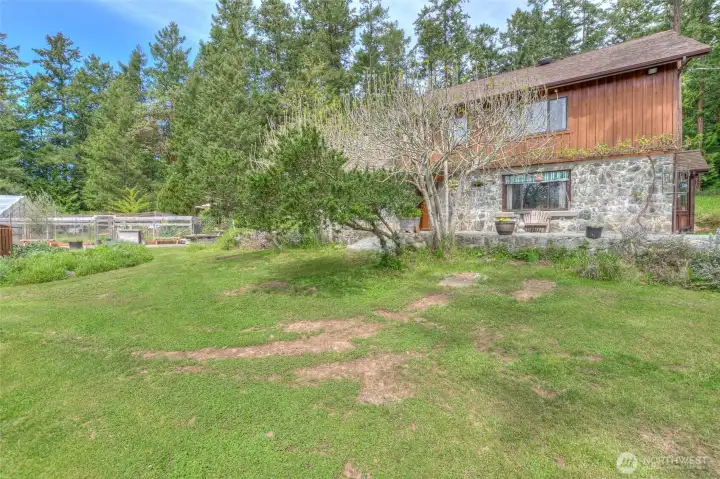 An outdoor person’s paradise with trees, shrubs, plantings and garden areas.