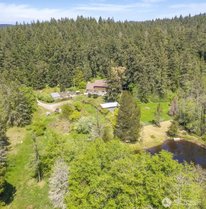 Aerial overview of the property shows the pond location in relationship to the home