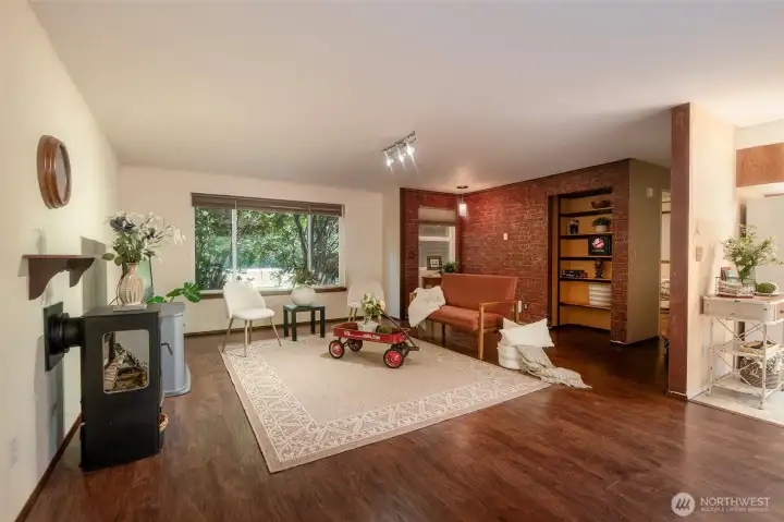 This spacious front living area features a gas stove, built-in shelving & a perfect spot for a desk under the window to the right. A large picture window frames the peaceful, wooded setting beyond. An inviting space w/room to spread out. This spacious front living area features a gas stove, built-in shelving & a perfect spot for a desk under the window to the right. A large picture window frames the peaceful, wooded setting beyond. An inviting space w/room to spread out.