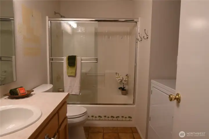 Main floor full bath & laundry to the right w/built-in shelving. Main floor full bath & laundry to the right w/built-in shelving.