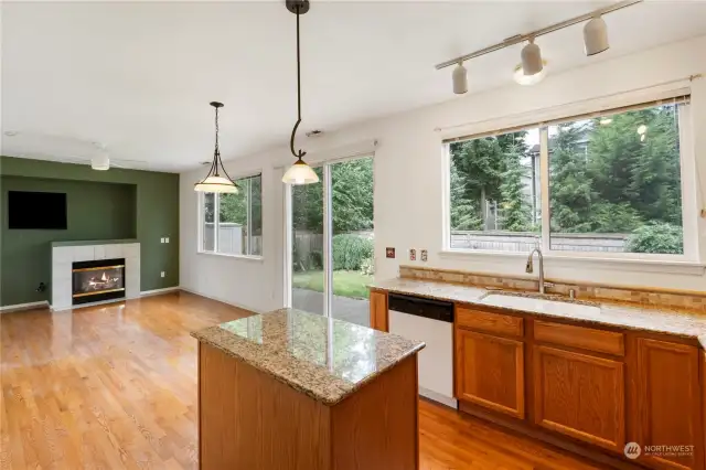 Kitchen has granite countertops and looks onto the beautiful yard.