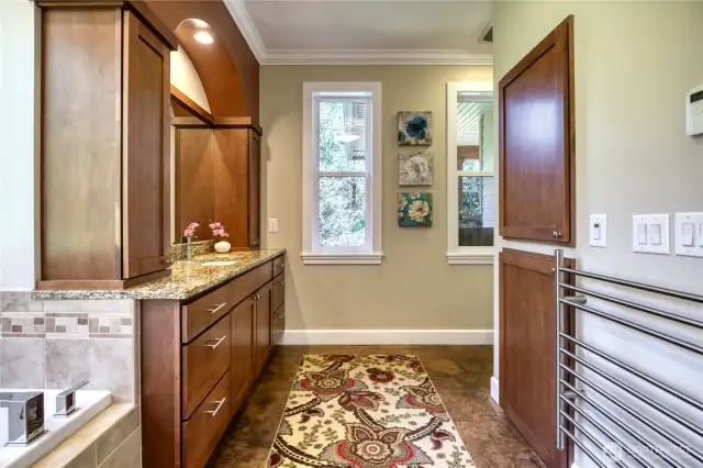 Another view of primary bath with plenty of storage, towel racks.