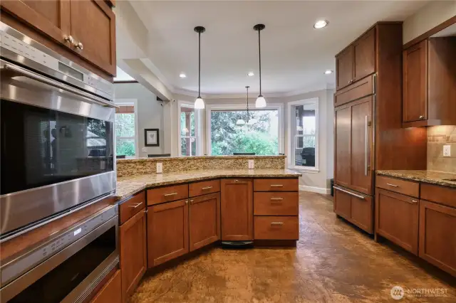 Gourmet kitchen with granite counter tops, with stamped colored concrete flooring throughout the mail level.