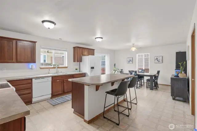 Generously sized kitchen and island.  Ample cabinet space. Dining area with slider to the backyard.