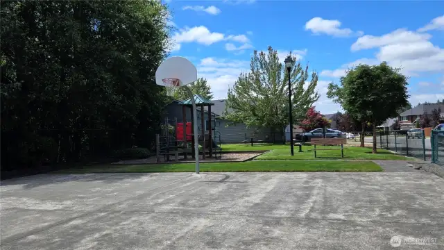 Picture of the fenced park basketball area.