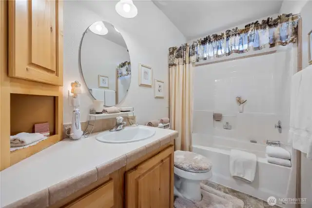 Shared guest bathroom with tub and shower.