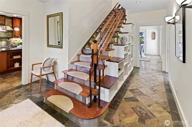 Custom built stairwell with custom iron work detail. Entry to hallway and dining room. Kitchen on the left