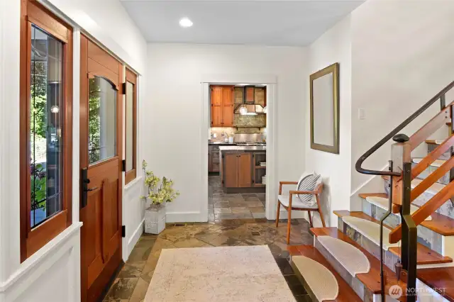 Once inside you'll love the custom built stairway and iron work. Warm slate floors.