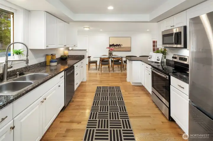 The updated kitchen! Definitely room for all of the cooks here. Stainless appliances and lots of cabinet space. You can see the large dining space at the other end of the kitchen.