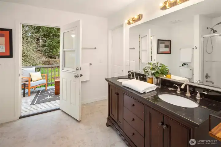 The upper primary en suite full bathroom boasts a sweet deck (newly refinished) that overlooks your backyard. The door on the right leads to the walk-in closet.