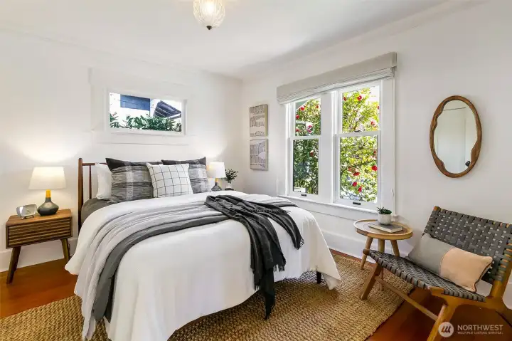 Main level front bedroom looks out onto a flowering garden and gets excellent morning light.
