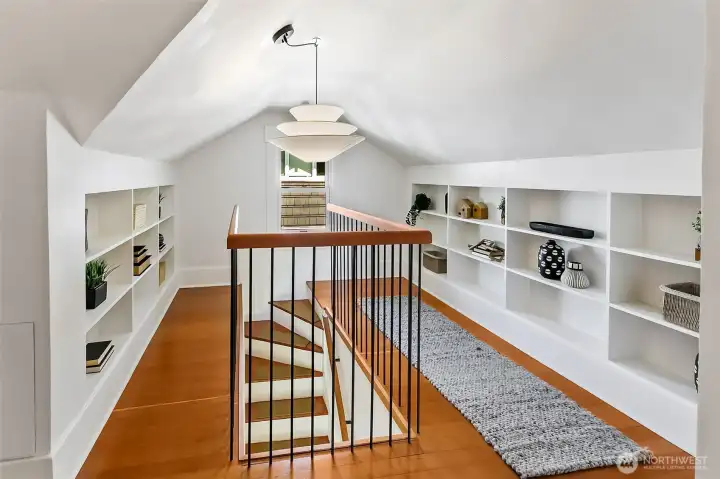 Upstairs in the 1/2 story find picturesque built-in bookshelves, fir floors, bedroom, den & closet.