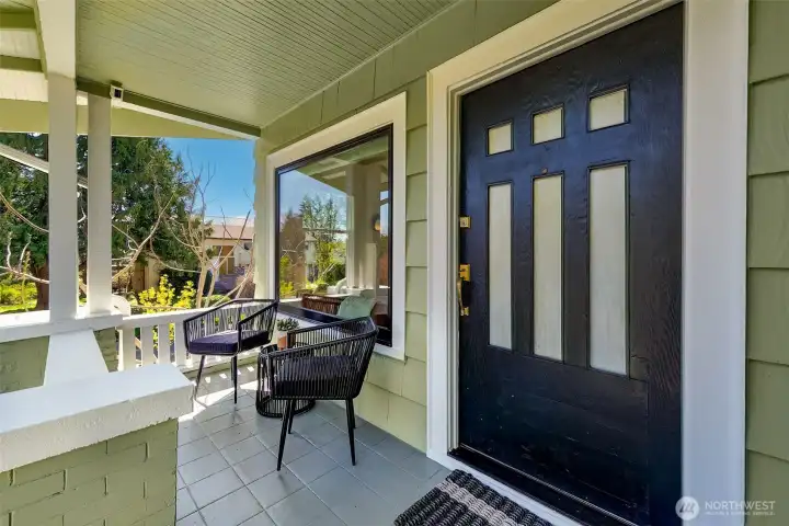 Picturesque covered front porch with period details and charming original 1913 front door.