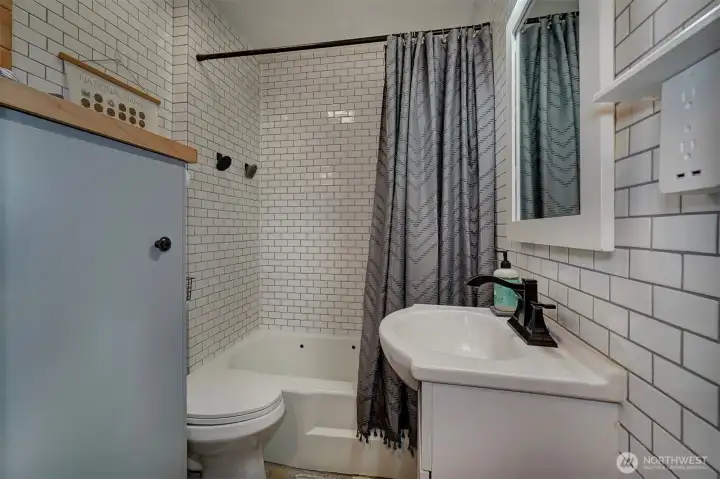 The full bath has been remodeled with white subway tile to give it a classic look.
