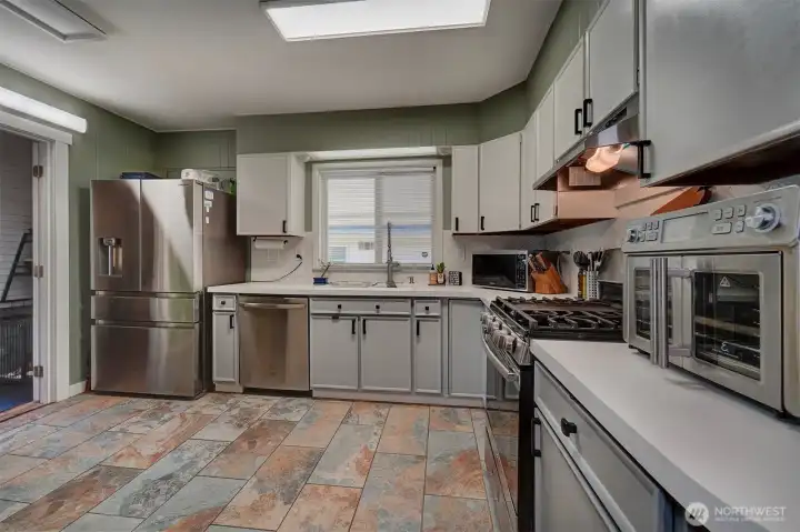 Open kitchen has plenty of space and stainless steel appliances.