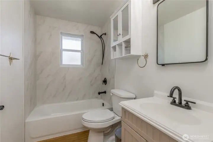 Newly renovated bathroom featuring a brand-new tub, shower, and updated plumbing