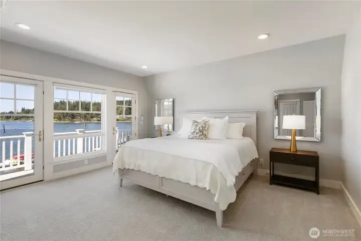 The luxurious upper-level primary suite serves as a private retreat, offering a front-row seat to spectacular sunsets and a private deck overlooking the bay.
