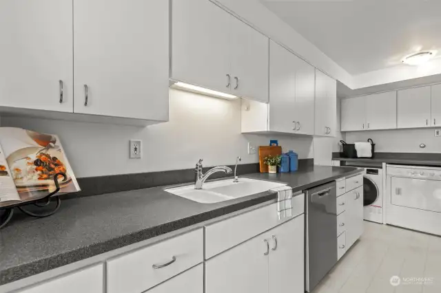 The kitchen is equipped with new matching Frigidaire stainless steel appliances and elegant Corian counters