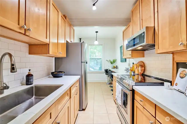 Spacious galley kitchen with quartz counters, new appliances and sprawling breakfast nook.