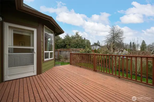 Looking across the deck toward the rear yard with fruit trees.