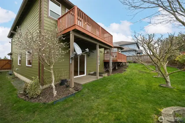 Looking at the rear of the home and the side yard with a gate at the fence.