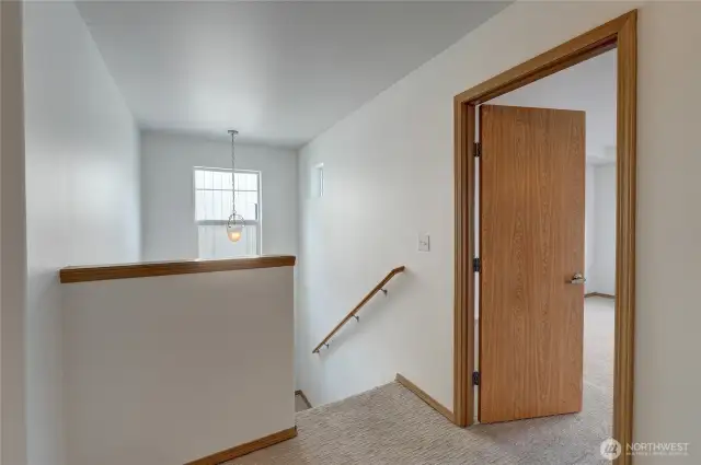 Upper landing. Door at the right is the primary bedroom.