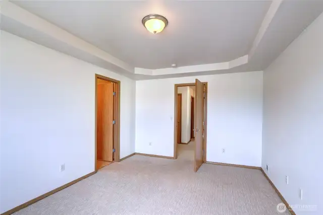 Note the pan ceiling adding visual height to the room. Door at left leads to ensuite and walk-in closet.