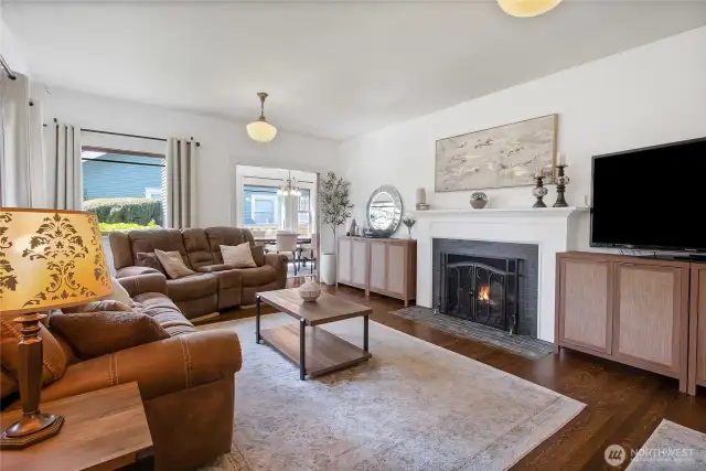 Living room with hardwoods and a wood fireplace.