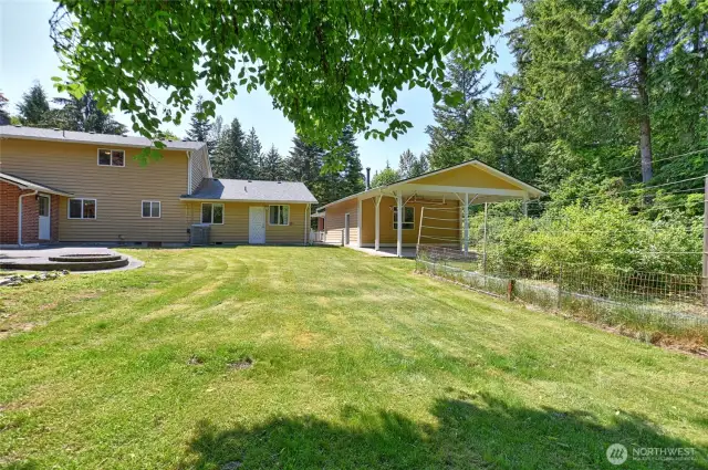 Back of house, detached garage with additional 2 car carport, fenced garden area