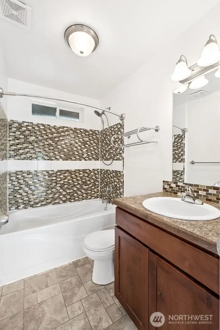 This bath keeps it simple, with vinyl waterproof flooring and a tiled surround at the shower-tub and vanity. A shaker vanity gives you storage without fuss, while high-set privacy windows bring in light and fresh air without putting you on display. Combined with the front bedroom right next door, this is an extra convenient setup for guests.