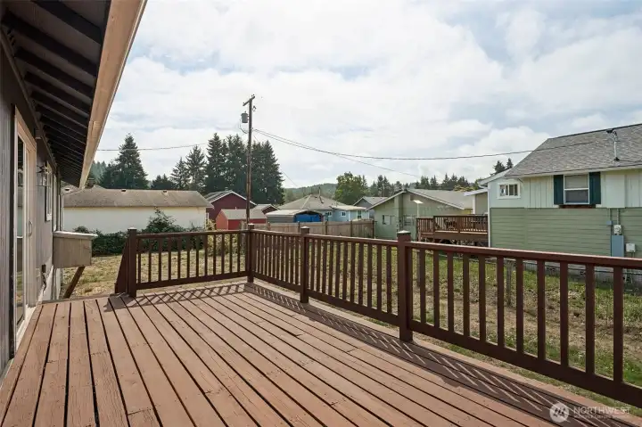 The back deck off the sliding glass door gives you space to actually live outside. There’s room for a dining table, a grill, and a seating area, plus railing all around for a finished look. Add a few container gardens and you’ve got a backyard view that works for morning coffee or Friday night BBQ.