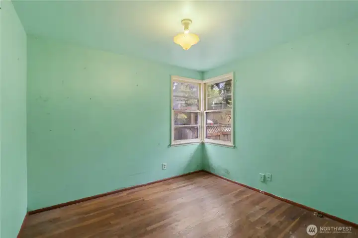 Bedroom #3 at the end of the hallway with hardwood flooring.