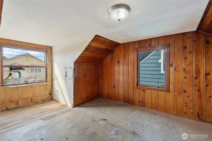 Bedroom #4 upstairs with wood paneling details and large windows for great natural light.