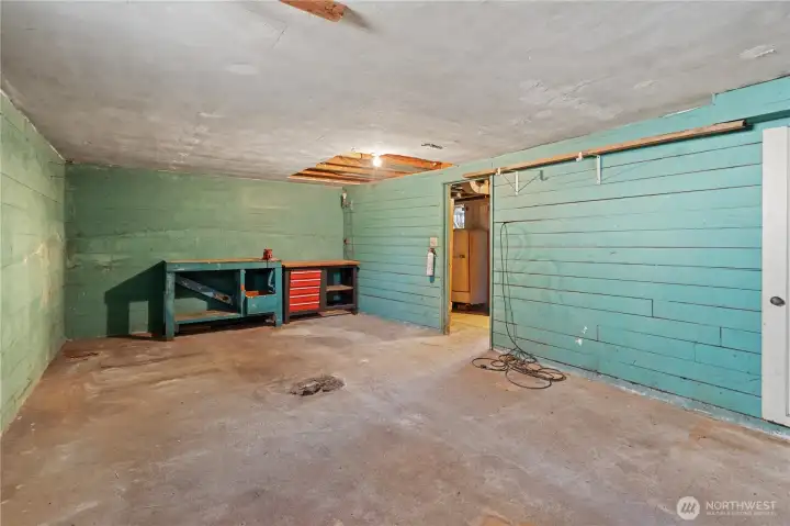Attached 1-car garage with a workshop area in the corner.