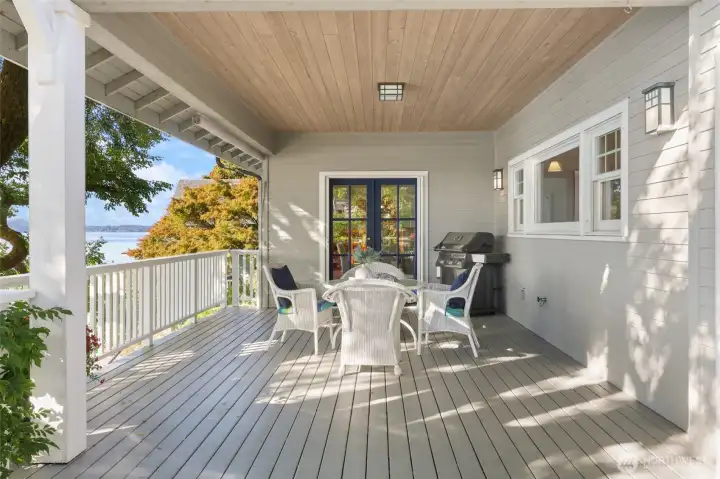 The covered portion of the deck with tongue and groove ceiling, pull down shade, gas plumbed BBQ (stays with house) and view of The Olympics.