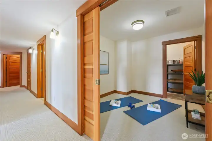 Room for watching tv, yoga, playroom, . . . Notice the solid wood pocket doors and the door leading into a large storage area.