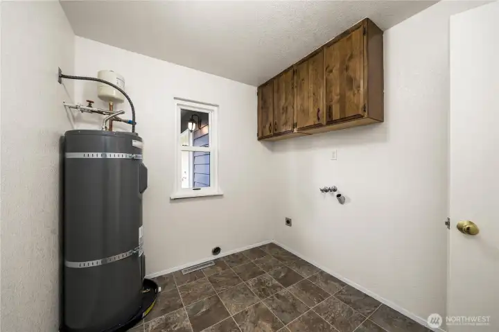 Water tank located in the laundry room that includes a washer/dryer hookup + cabinet space for added storage.